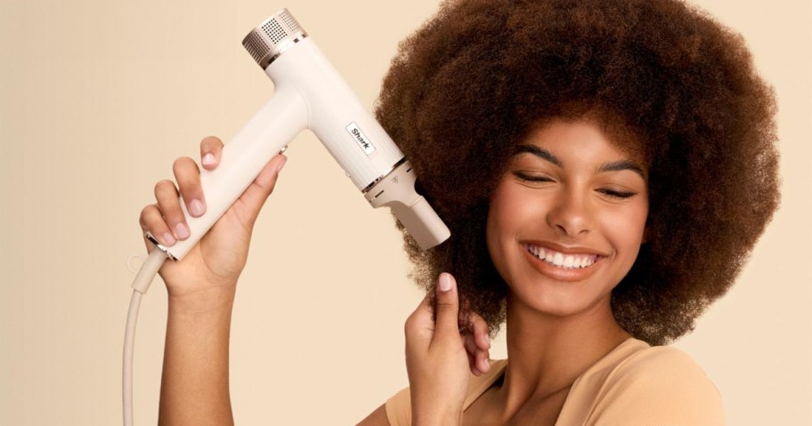woman using white shark hair dryer on hair