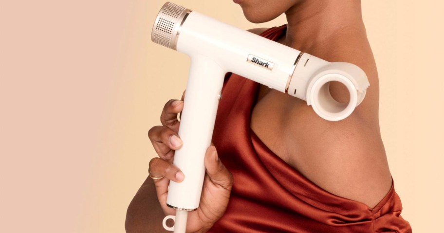 woman holding white shark hair dryer with attachment