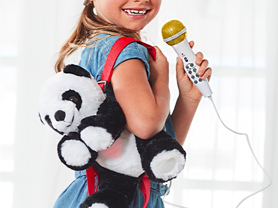 girl wearing panda backpack with microphone in hand