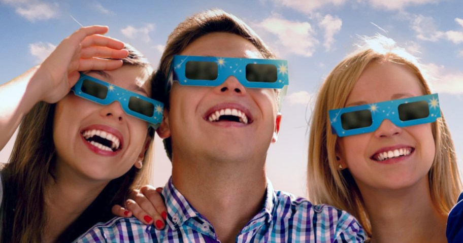 3 people wearing solar eclipse glasses