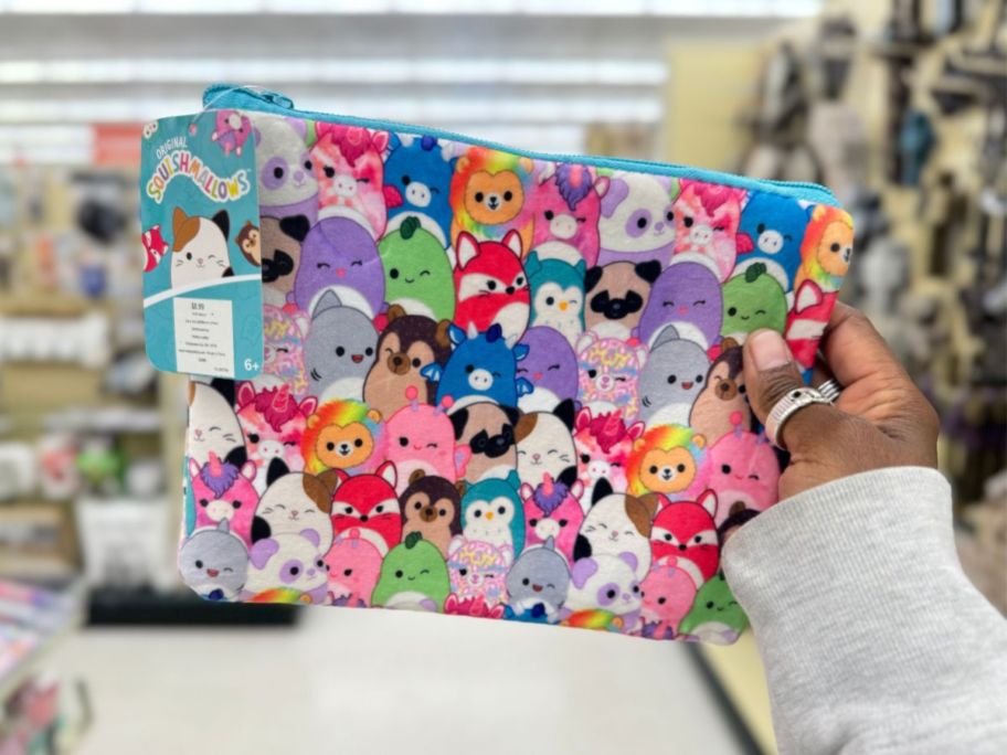 hand holding a Squishmallows zipper pouch with various characters on it 