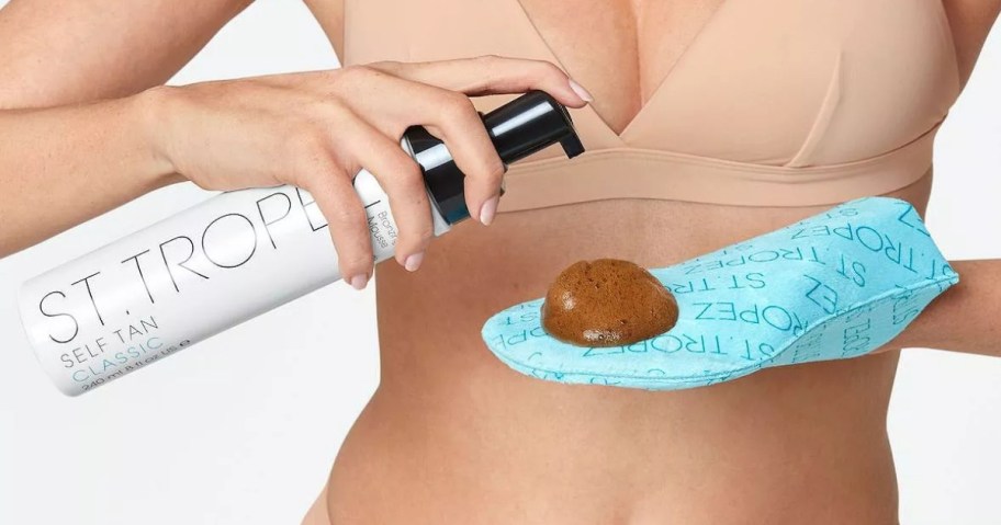 woman putting St Tropez Tanning lotion onto a tanning mittt