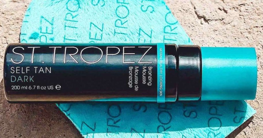 bottle of St. Tropez Self Tan Dark Bronzing Mousse on a tanning mitt