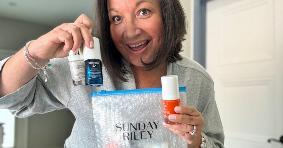 woman holding sunday riley travel skincare items