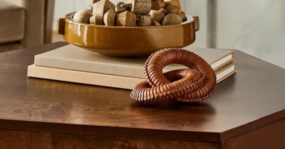 leather round links decor on a coffee table with a bowl of wood shapes behind it