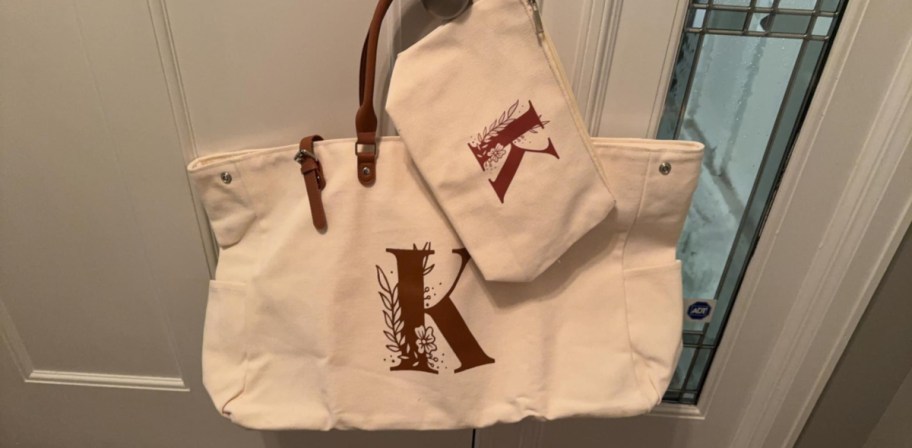 tote and makeup bag set with the letter K displayed on a. door handle