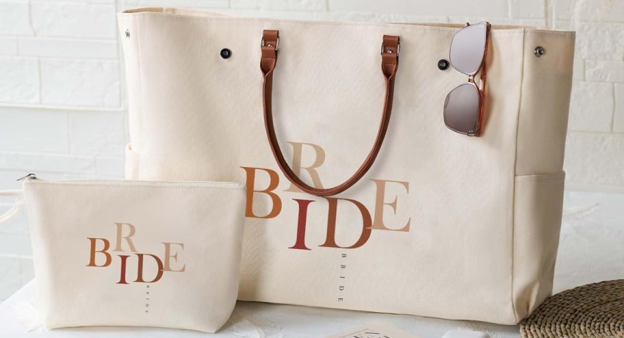 tote and makeup bag with the words bride on them displayed on the table