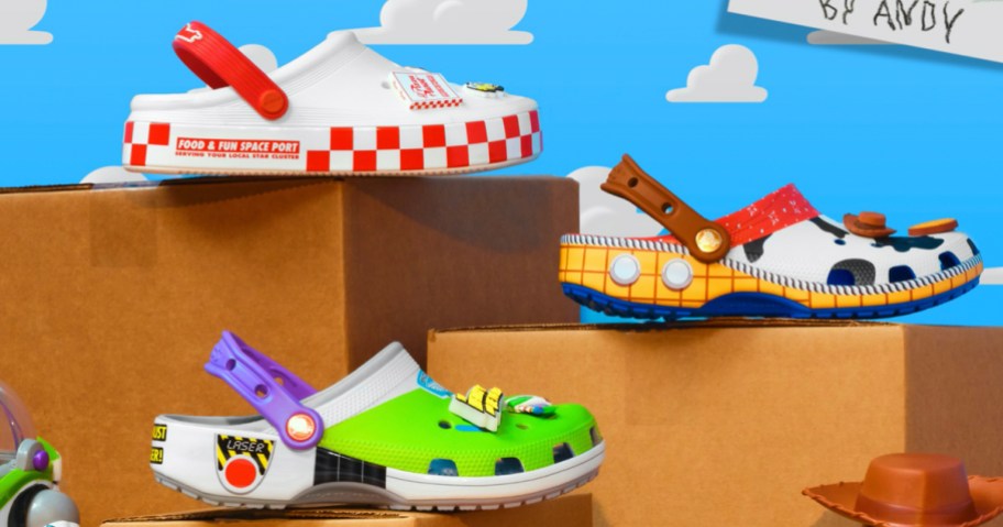pizza planet, woody, and buzz lightyear crocs sitting on boxes