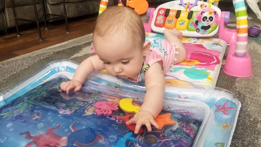 baby playing on water mat