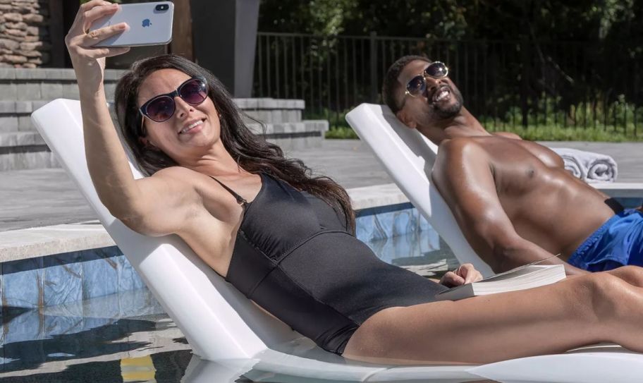 a couple lounging in the pool on vero lounger taking a selfie