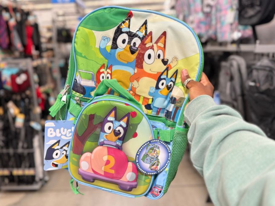 hand holding a Bluey kid's backpack and lunch bag set