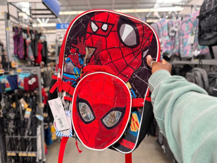 hand holding a Spiderman kid's backpack and lunch bag set
