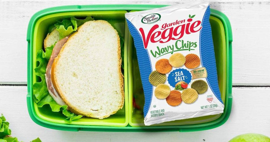 a bag of veggie chips in a bento box next to a sandwich