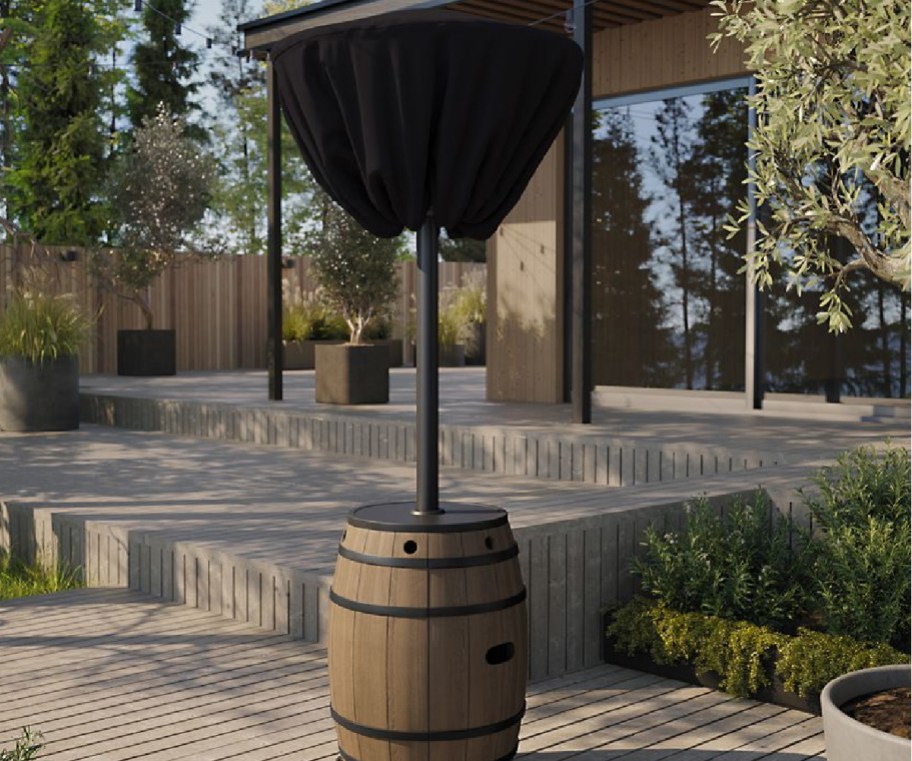 whiskey barrel patio heater with black cover on it