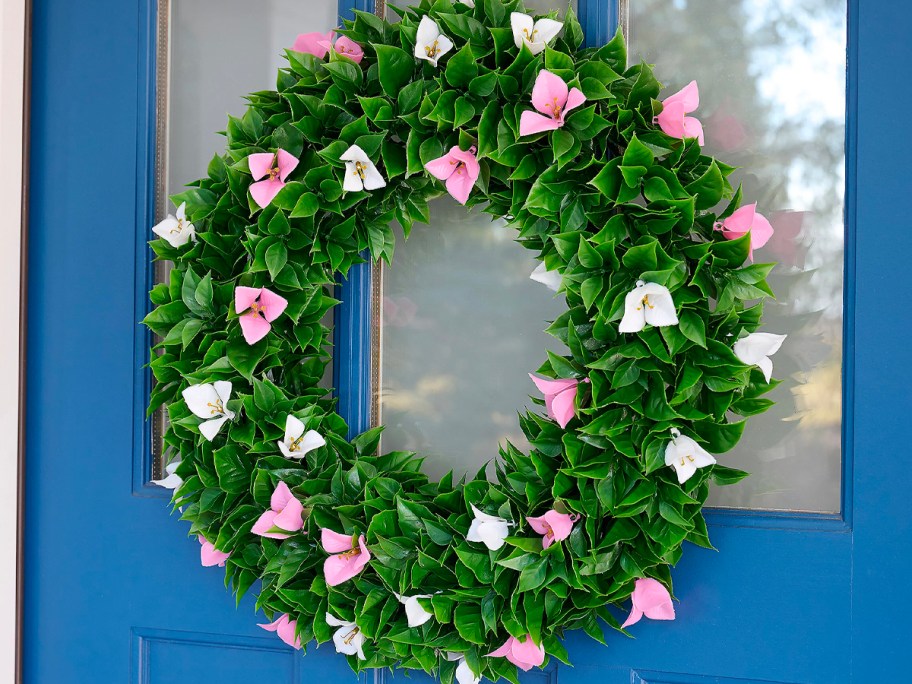pink and white flower wreath hanging on blue front door