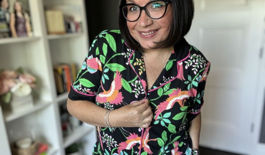 a woman wearing a set of black jungle print pajamas