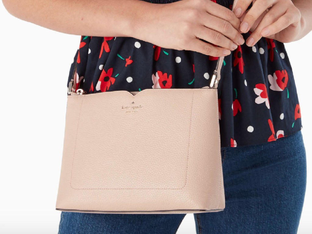 woman wearing Kate Spade Harlow Crossbody in a peach tone with a flower blouse