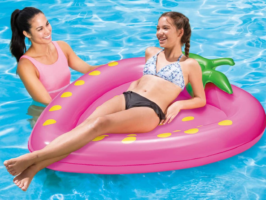 women on strawberry float at the pool