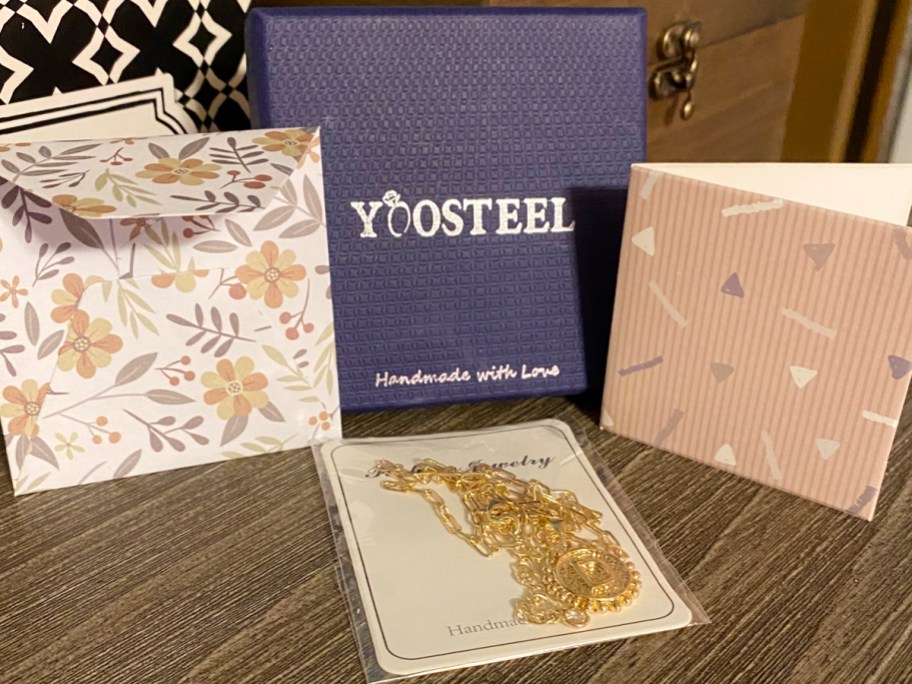 yoosteel gift box with necklace and card on table
