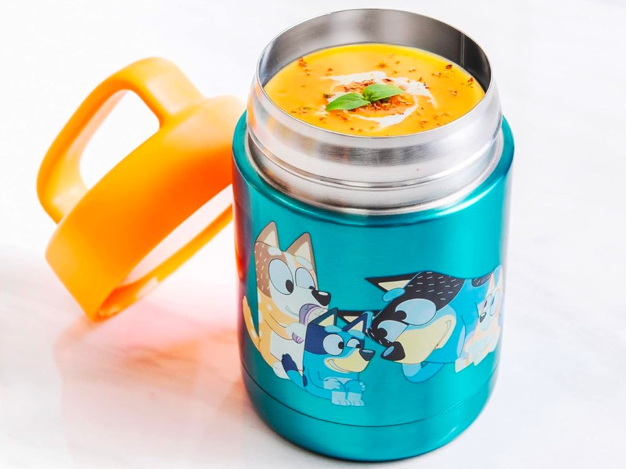 bluey food jar with soup inside and orange lid leaning on it