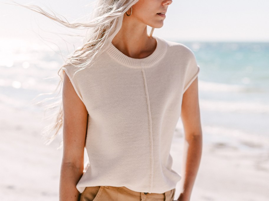 woman on beach wearing beige top