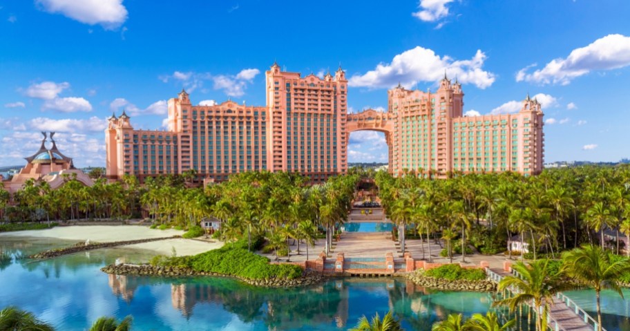 view of exterior of Atlantis Bahamas resort with beach and pools and palm trees