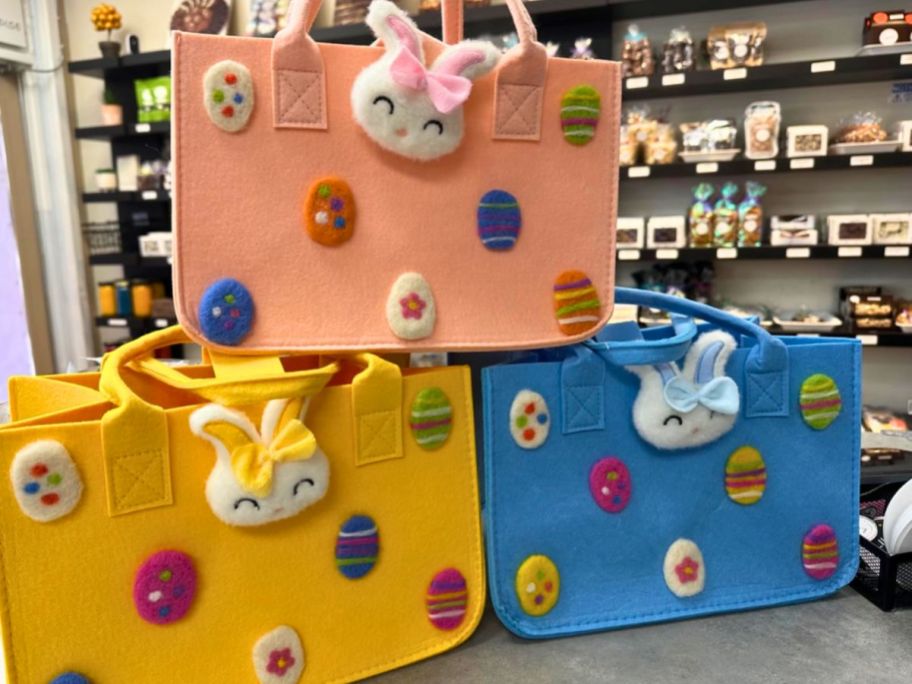 Felt Easter bags in blue, pink and yellow with plush bunnies and eggs on them
