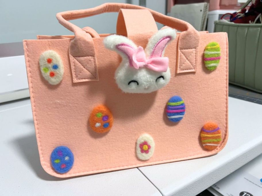 pink felt Easter bag with plush bunnies and eggs on it