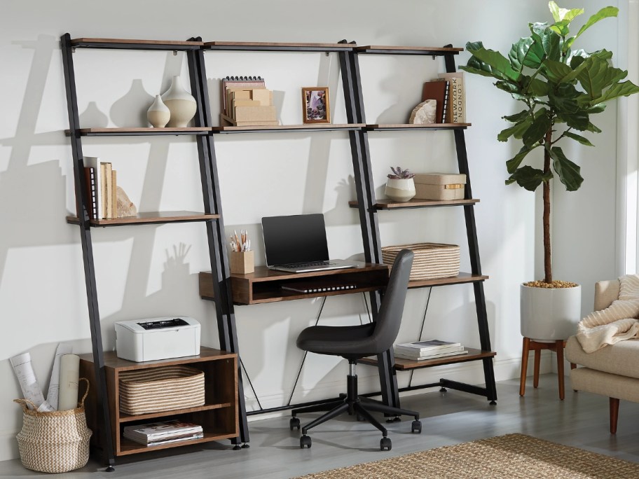leaning ladder style desk and bookcases with a laptop, books, printer and other decor