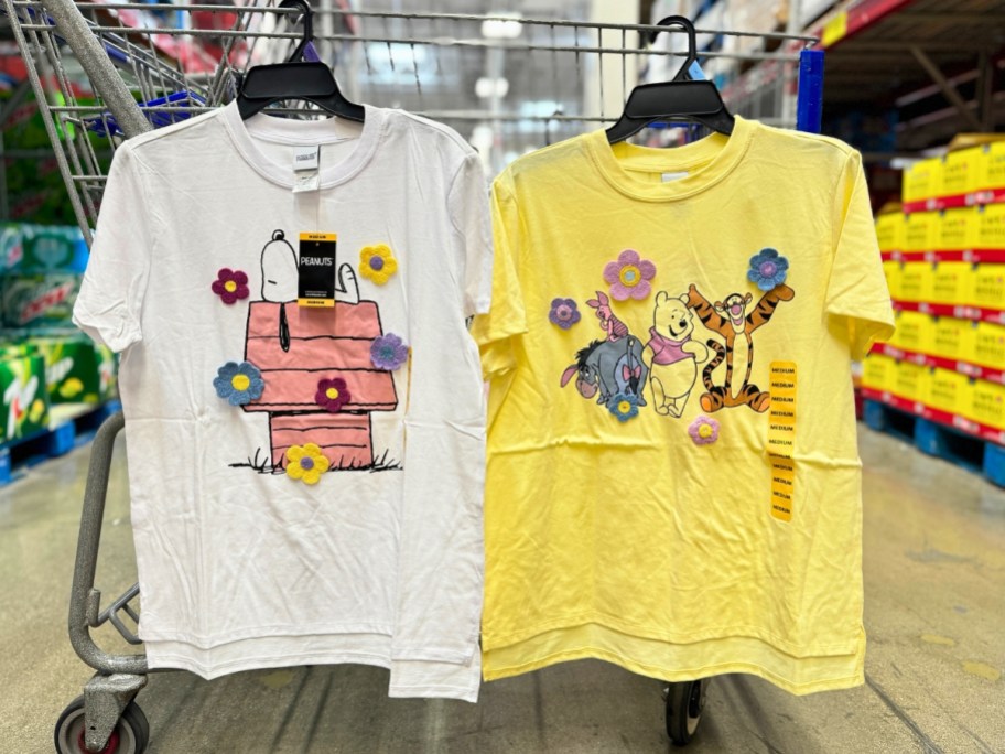 women's Snoopy and Winnie the Pooh t-shirts hanging from cart at Sam's Club