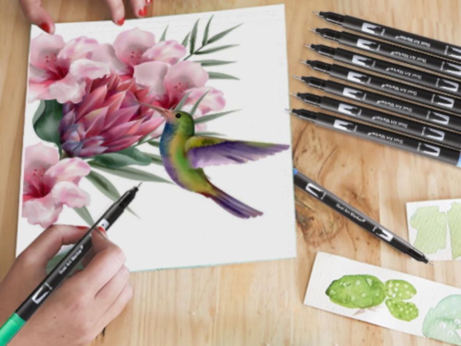 Hand drawing a picture of a hummingbird with double-sided brush markers
