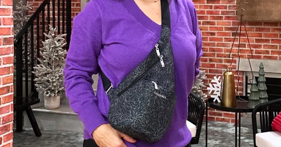 woman in a purple sweater with a black Baggallini Mini Sling bag