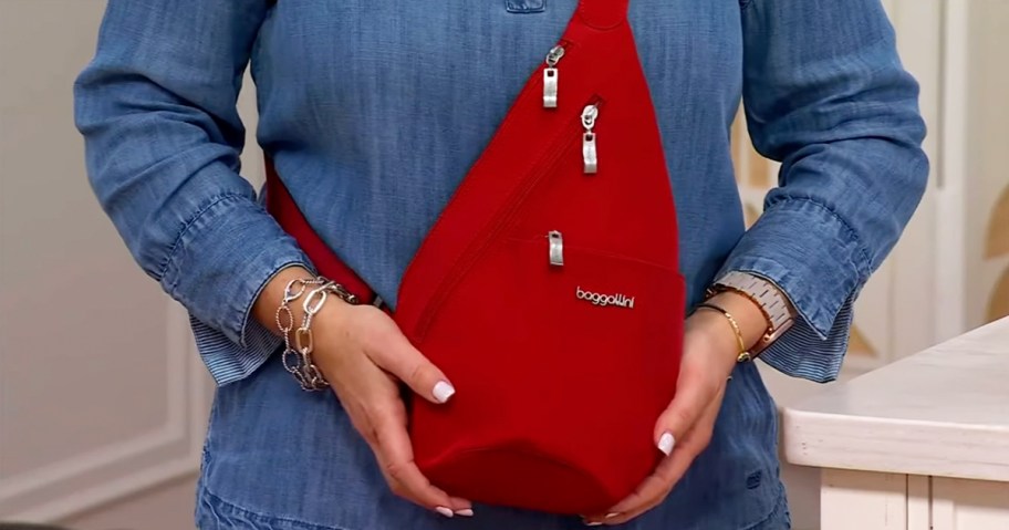 woman in a denim top with a red Baggallini Mini Sling bag