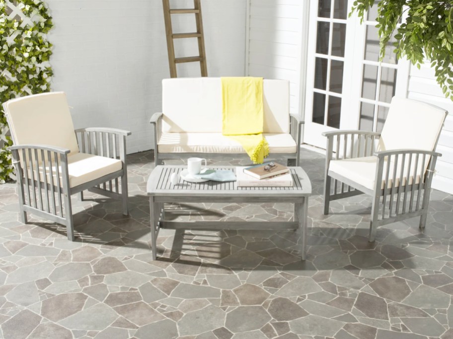 light grey patio seating set with white cushions and matching coffee table