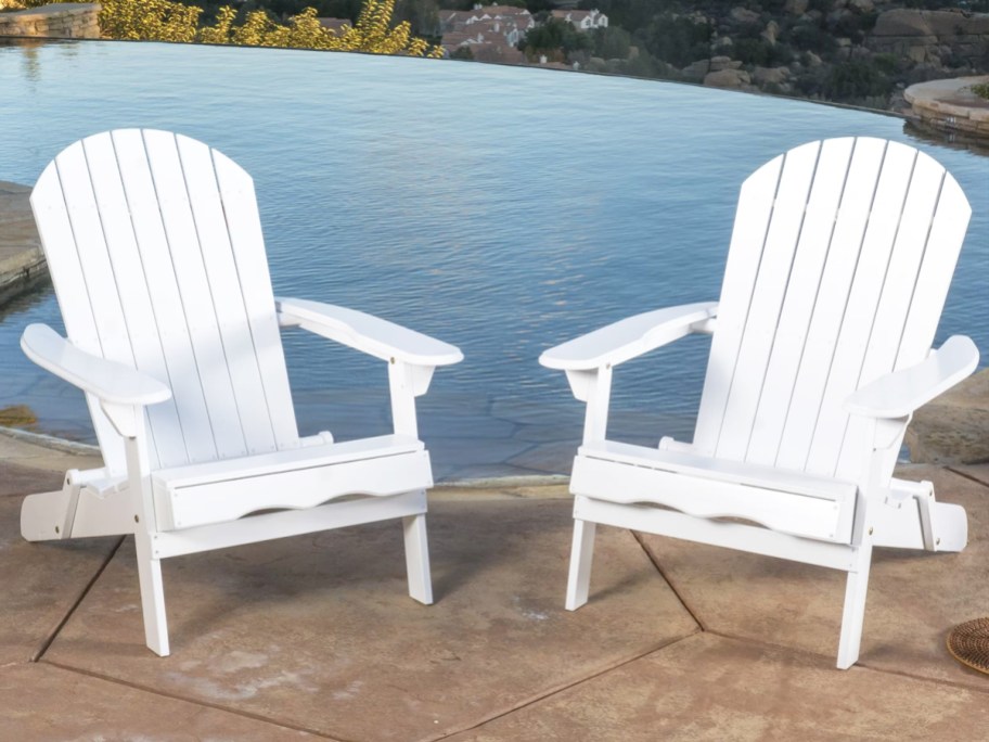 two white adirondack chairs near pool