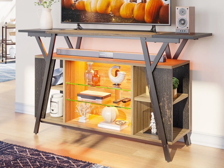 wood and metal tv stand with glass display shelves and lights