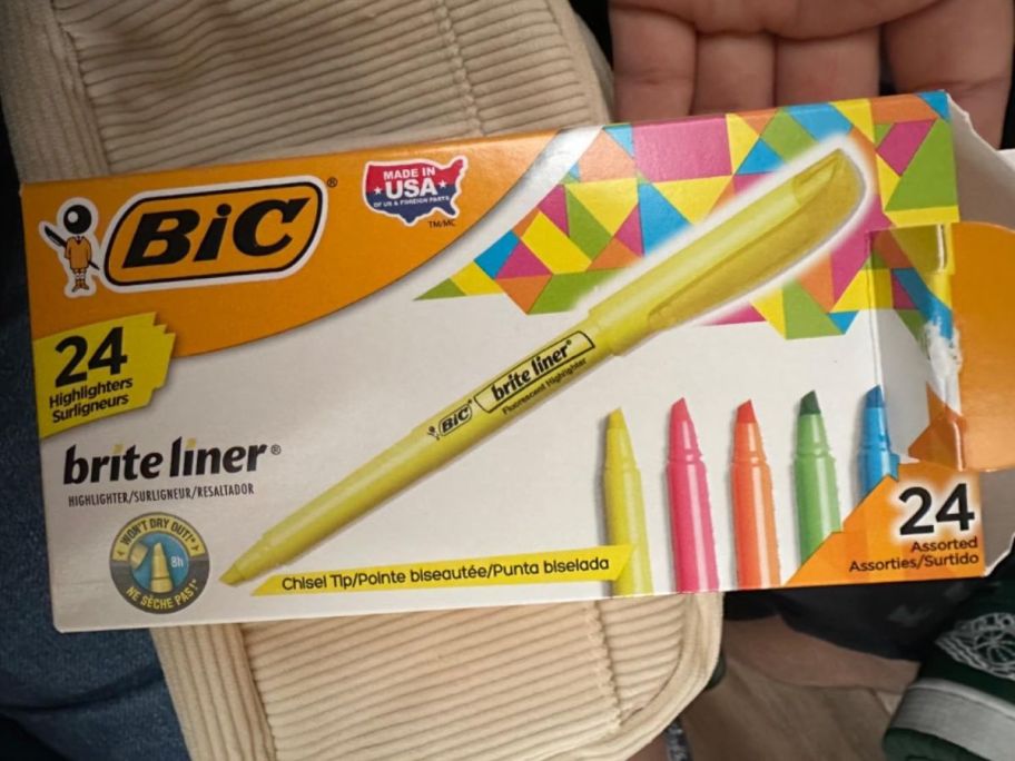 A hand holding a box of Bic Brite Liner Highlighters in Assorted colors