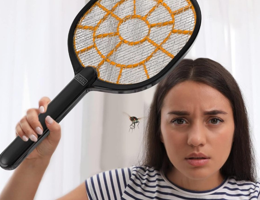 woman holding a Black+Decker Bug Zapper above a fly