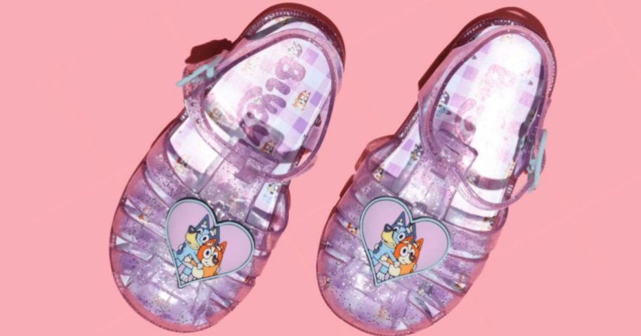 a pair of Bluey Toddler Girls Fisherman Sandals on a pink background 