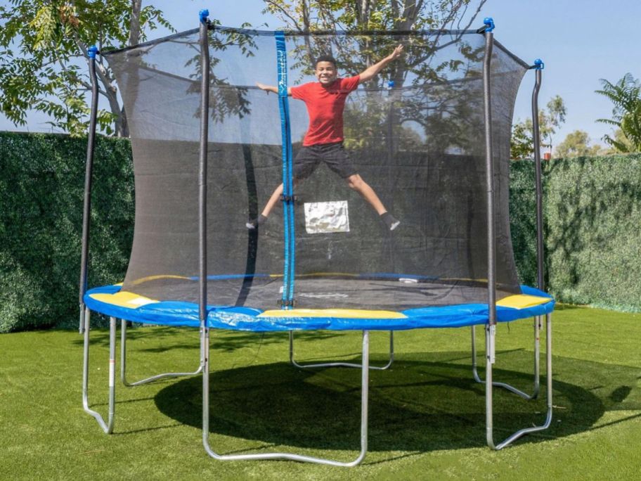 A child bouncing on a Bounce Pro 12' Trampoline with Enclosure Combo