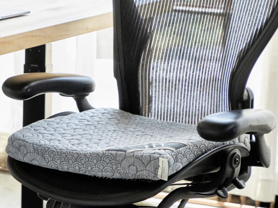 grey seat cushion on a black mesh office chair