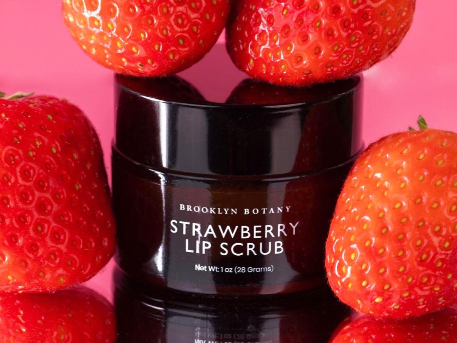 brown jar of Brooklyn Botany Lip Scrub surrounded by strawberries