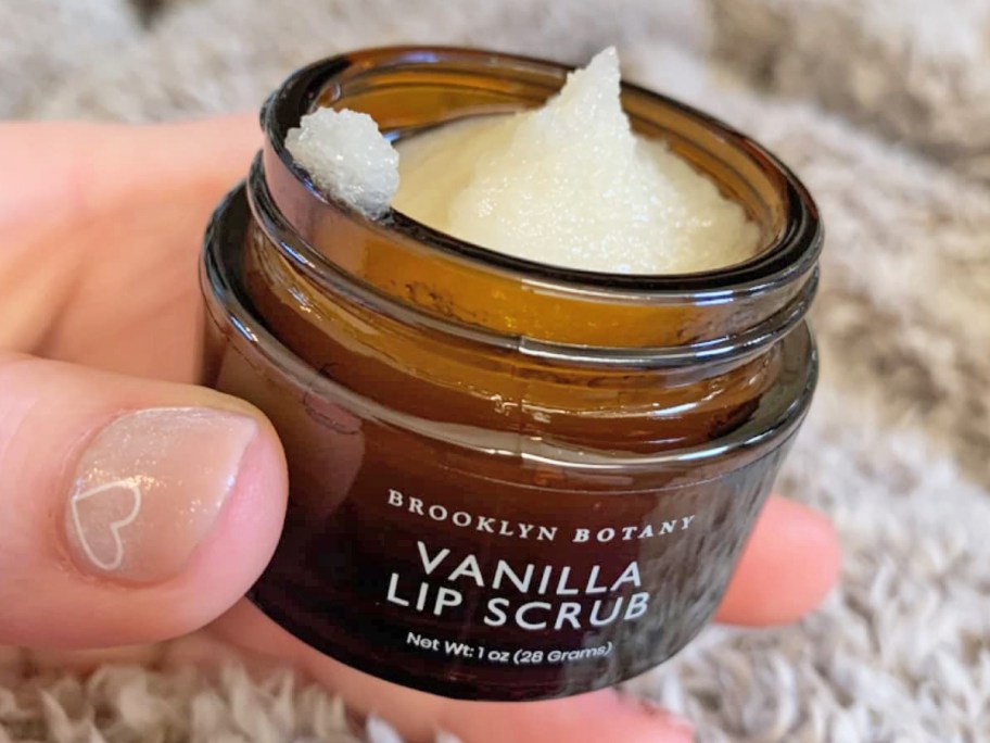 hand holding an opened jar of Brooklyn Botany Lip Scrub