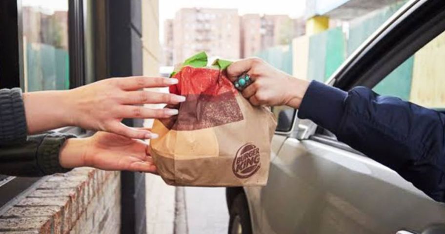 A person handing another person a Burger King bag