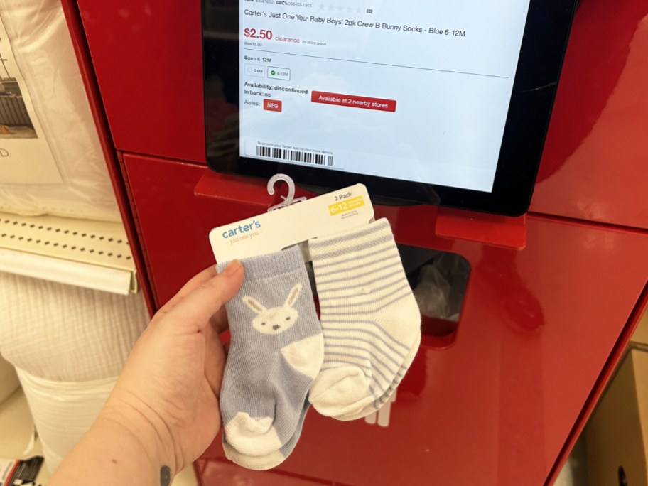 hand holding a set of baby socks to price scanner