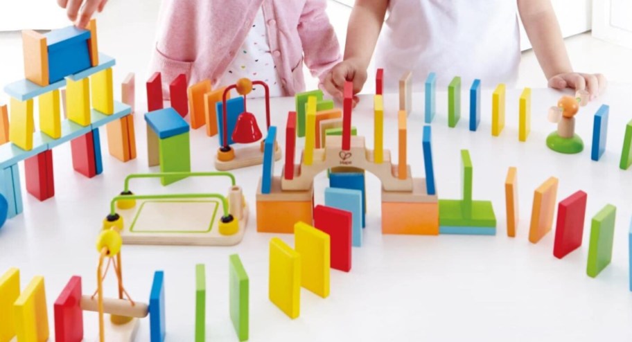Children playing with colorful domino blocks on top of the table