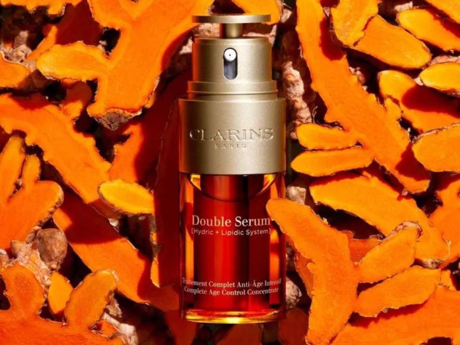 A bottle of Clarins double serum surrounded by orange peels