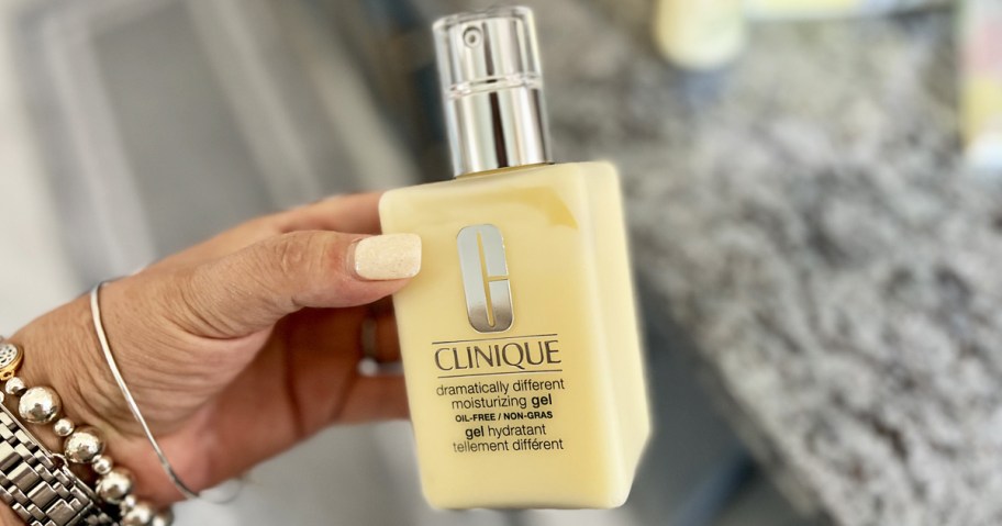 hand holding a yellow bottle of Clinique Dramatically Different moisturizer