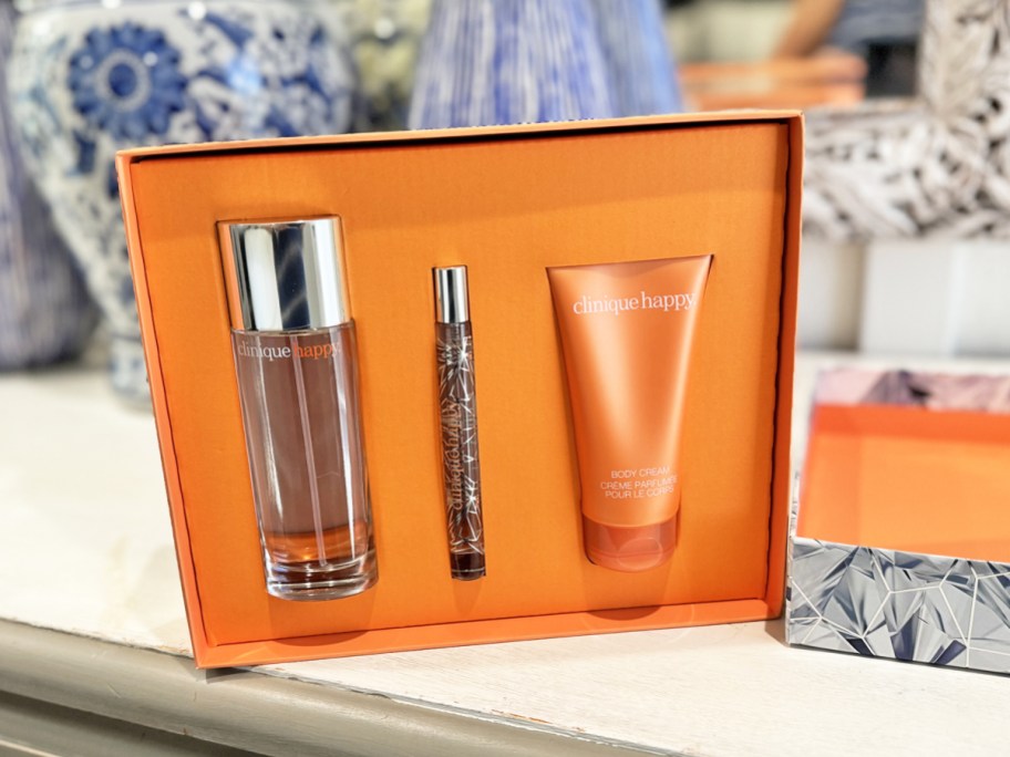 orange clinique happy perfume gift set on bathroom counter