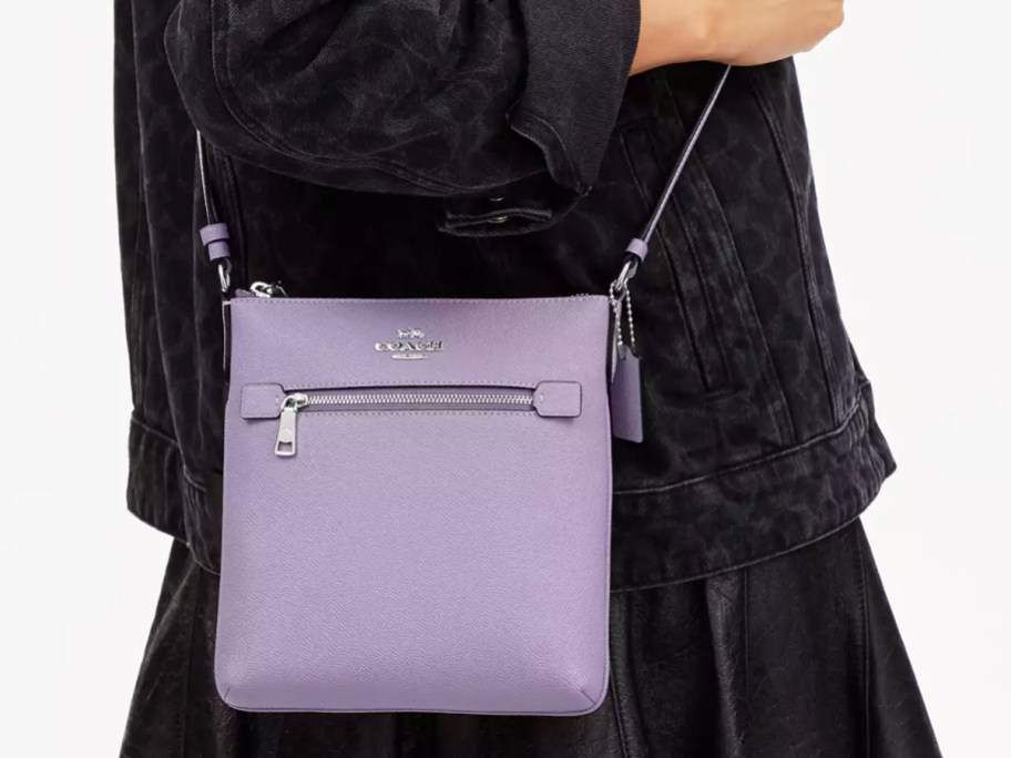 woman with black jacket and purple crossbody bag